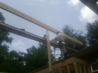 Carpenter setting a ridge beam over a new addition frame in Green Valley Lake