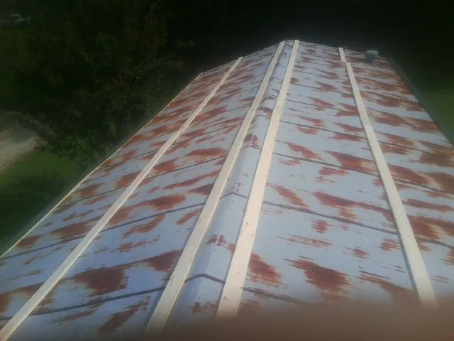 Rusted metal roof panels with new wood purlins before replacement — Storm Damage Roof Repair in Green Valley Lake by Roofing Brothers