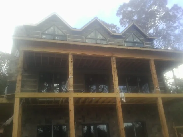 Dormers and porch framing on a large log home under construction — Roof Coating work by our crew in Green Valley Lake