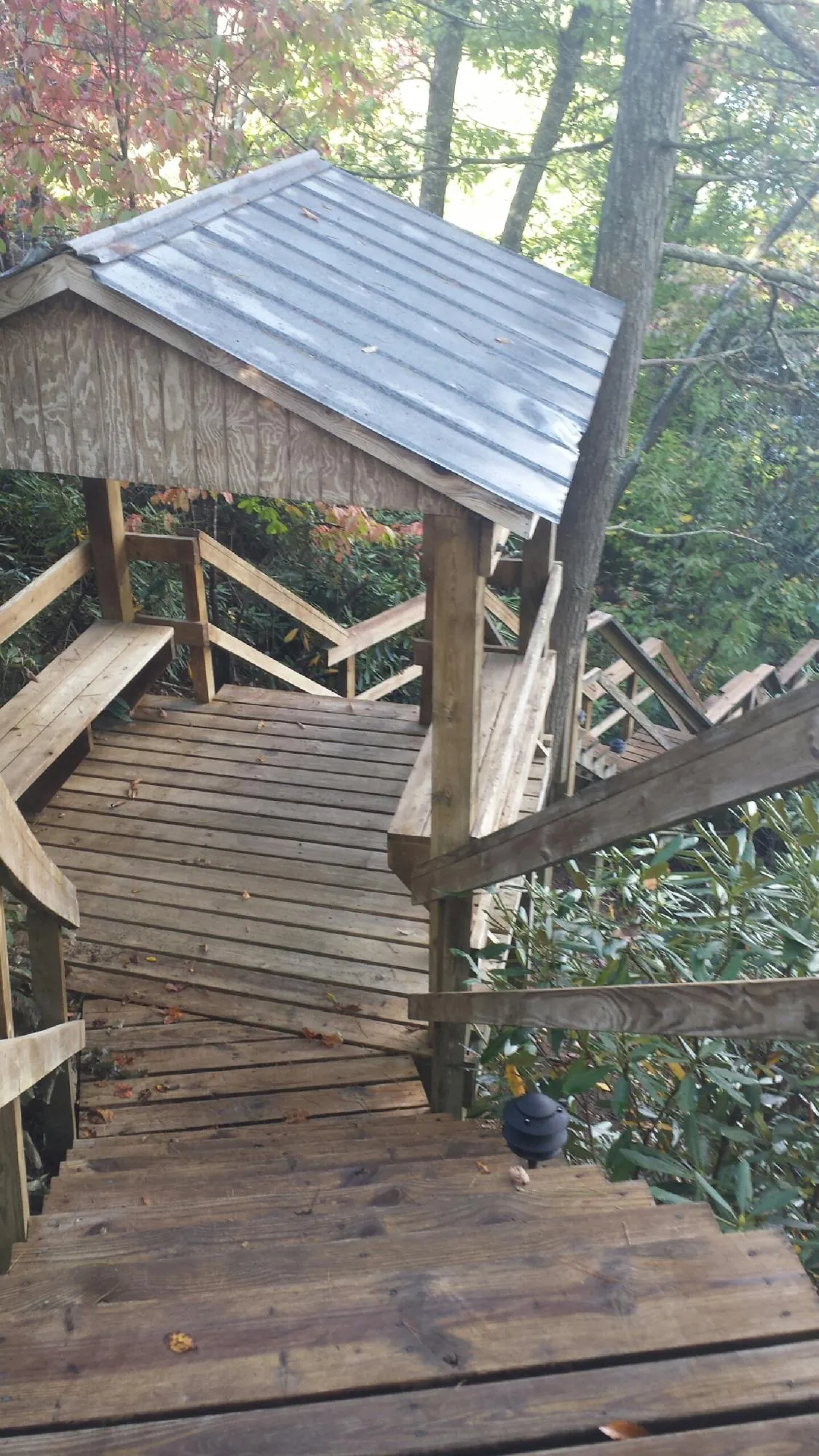 Metal roofed shelter over wooden steps on a wooded walkway — Skylight Repair & Installation work by our crew in Green Valley Lake